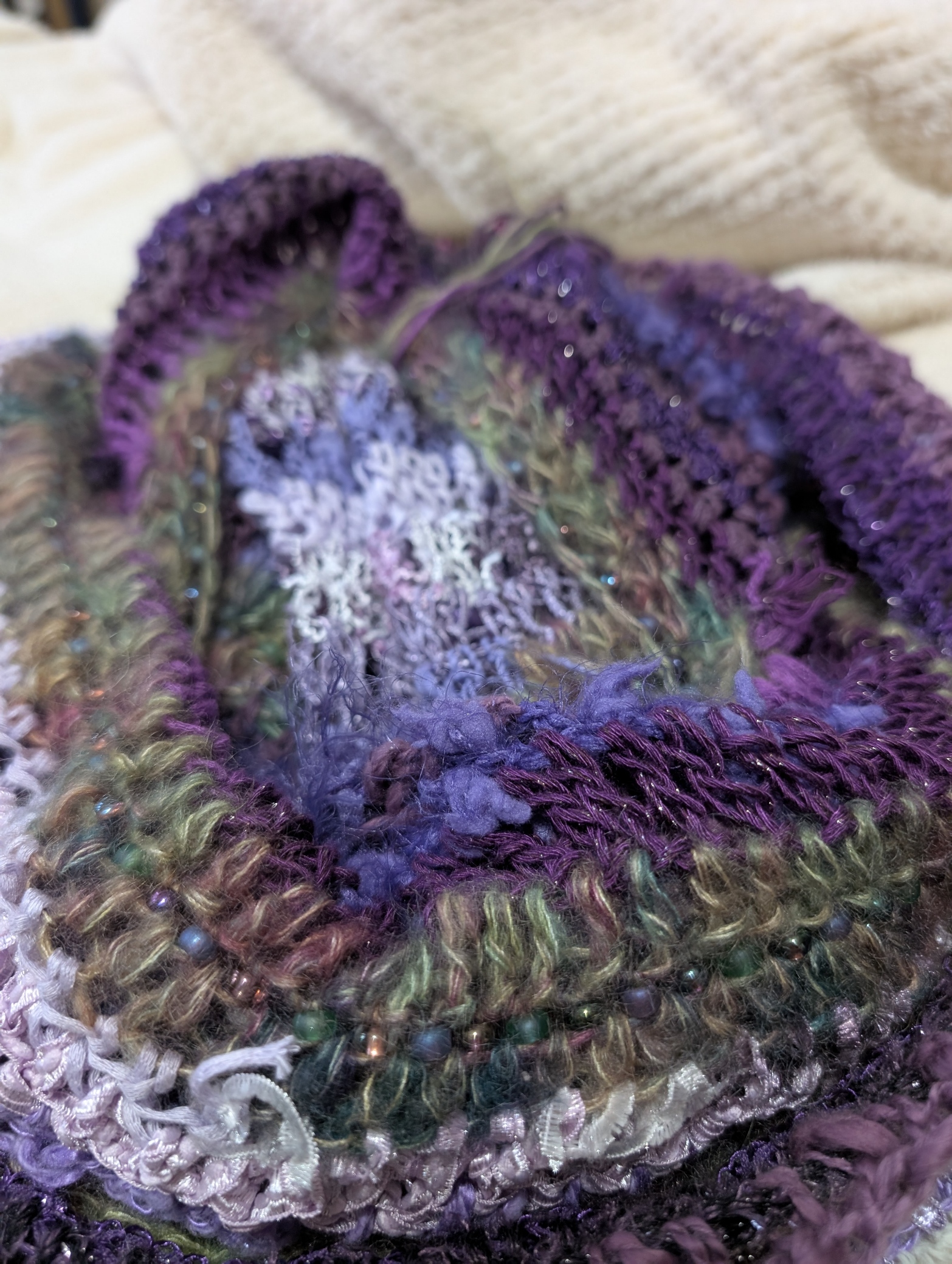 A beaded poncho made by the author of the website is used as the featured photo on the site. The poncho is unfolded to add contrast to the image and the colours in the piece. It was hand-beaded. 